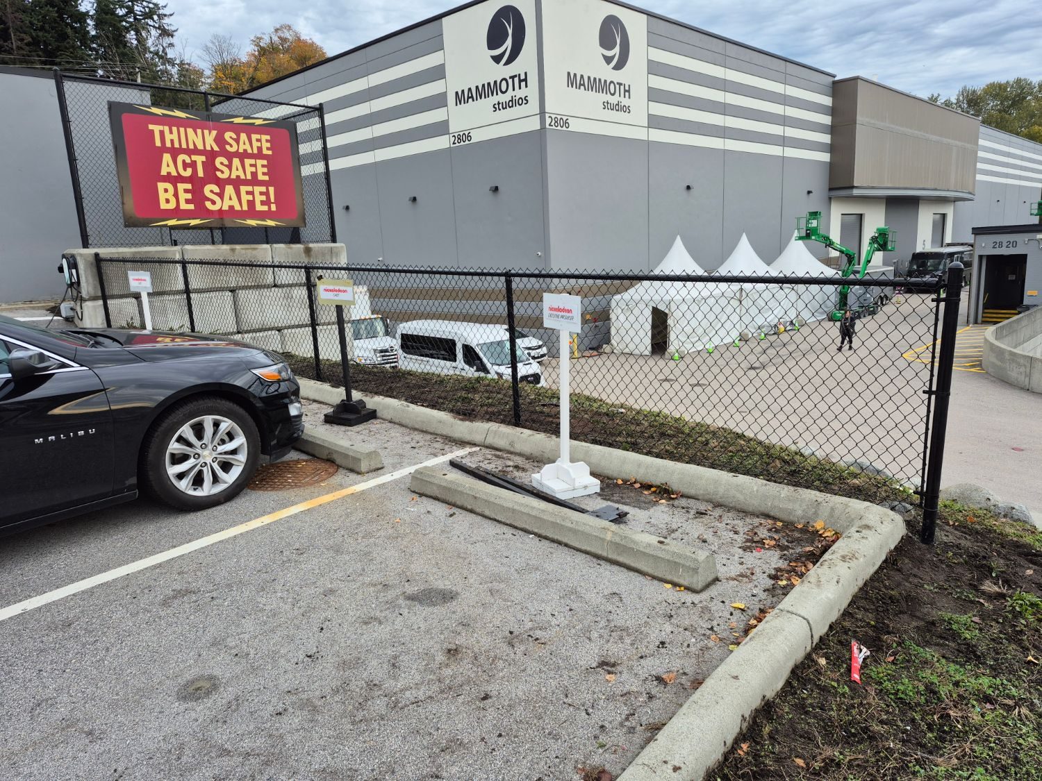 Black chain link fence along a commercial parking lot