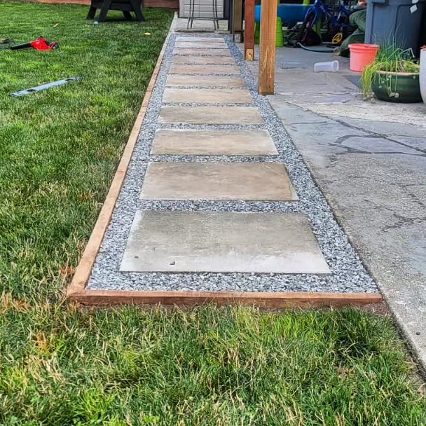 Stepping-stone path set in gravel with timber edging beside a lawn