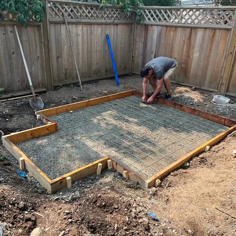 Wood forms and wire mesh laid over gravel for a concrete pad