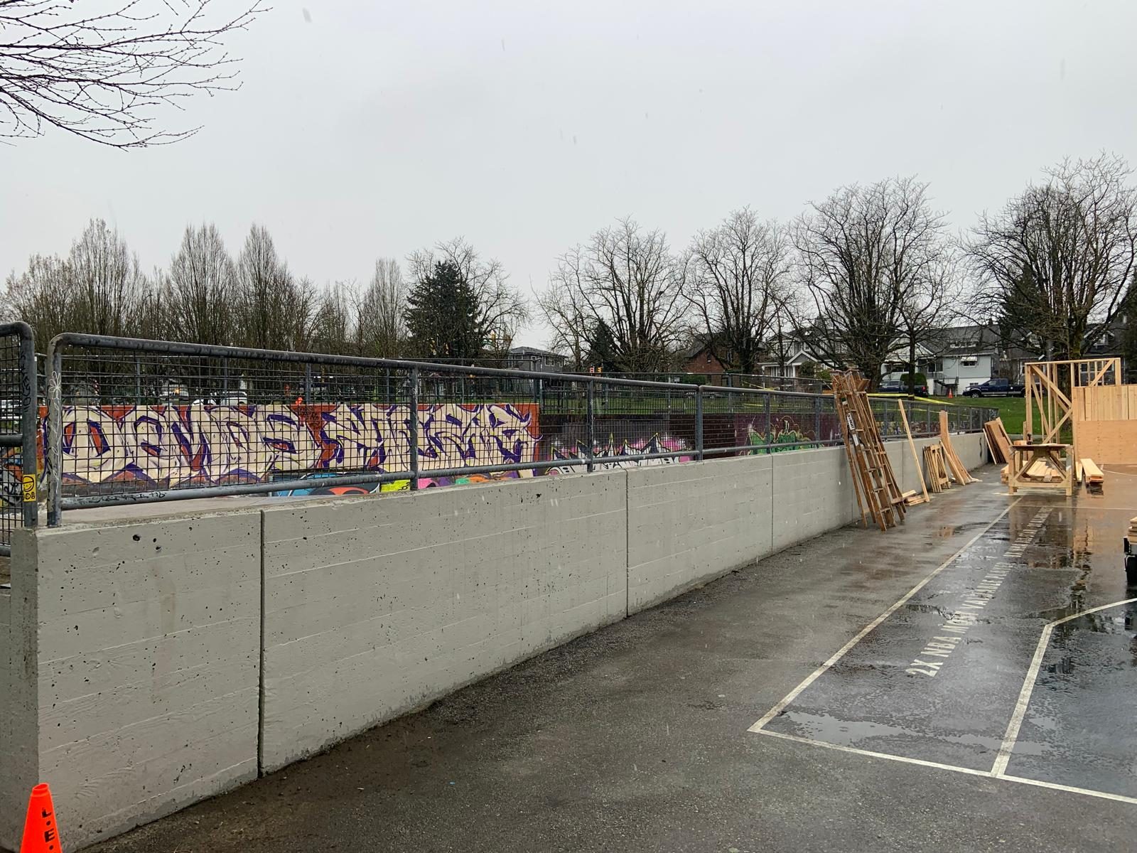 Concrete retaining wall with steel rail