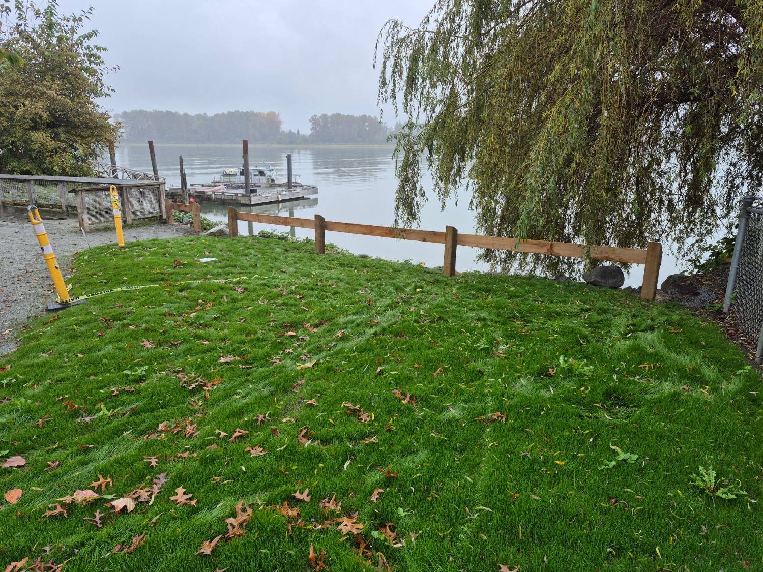 Post and rail fence at the river beside new lawn